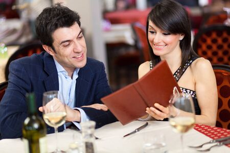 Couple reading menu in a restaurantの写真素材