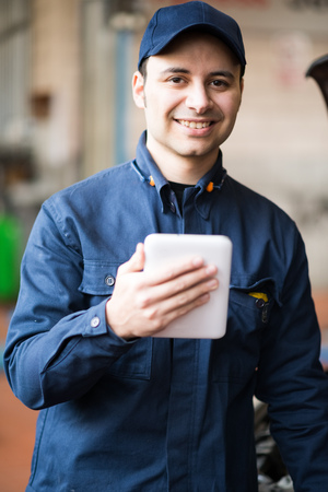 Portrait of a mechanic using a tablet in his garageの写真素材