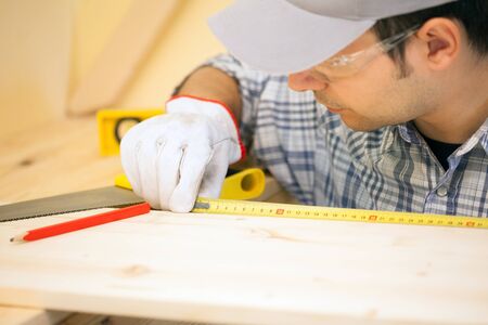 Portrait of a carpenter using a measuring tape