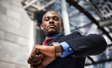 Handsome businessman looking at his watchの写真素材