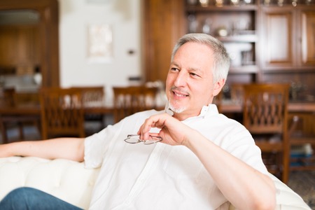 Portrait of an happy mature man relaxing on the couchの写真素材