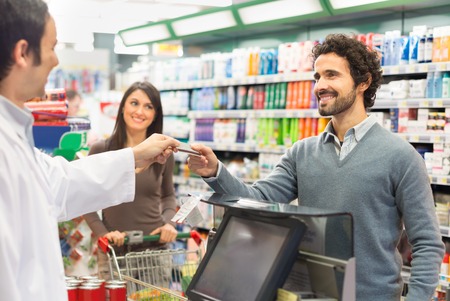 Customer using a credit card to pay in a supermarketの写真素材