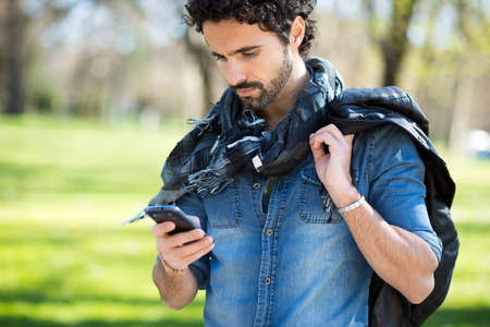 Portrait of a man using his mobile phone in a park