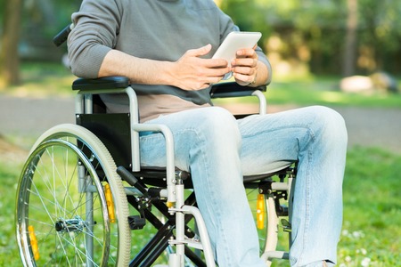 Detail of a disabled man using a tablet in a parkの写真素材
