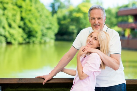 Portrait of an happy mature couple in front of a lakeの写真素材