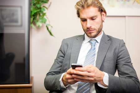 Portrait of a businessman using his mobile phoneの写真素材