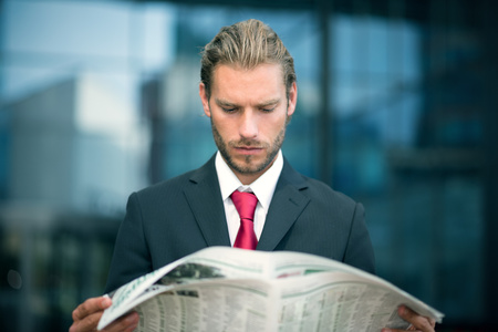 Handsome man reading a newspaperの写真素材