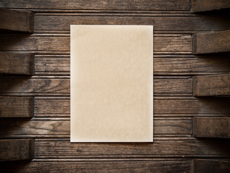 Close-up shoot of an old paper sheet on a wood wall