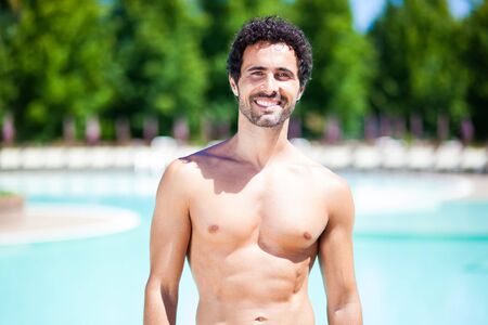 Smiling young man relaxing while on vacationの写真素材