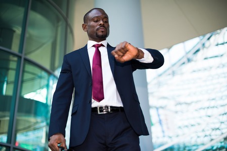 Handsome businessman looking at his watchの写真素材