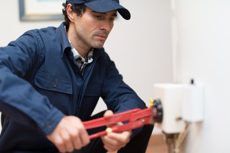 Plumber fixing an hot-water heaterの写真素材