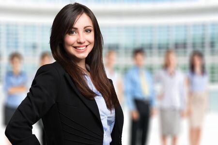Portrait of a smiling woman in front of a group of peopleの写真素材