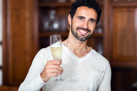 Man drinking champagne in his living roomの写真素材