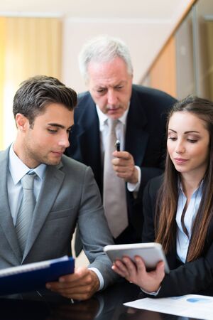 Group of people at work. Shallow depth of field, focus on the woman on the right