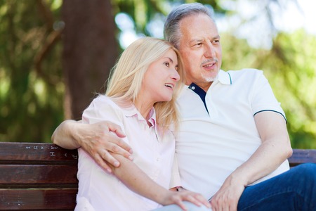 Happy mature couple sitting on a benchの写真素材
