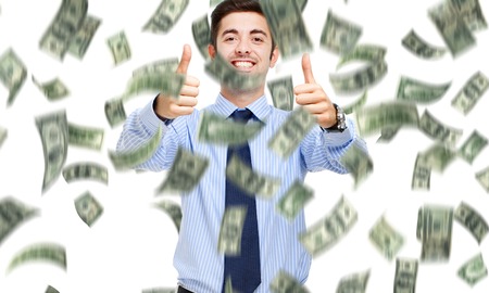 Happy man enjoying a rain of moneyの写真素材