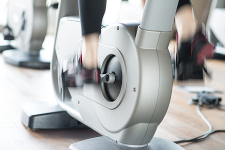 Detail of a woman working out on a stationary bike. Motion effect