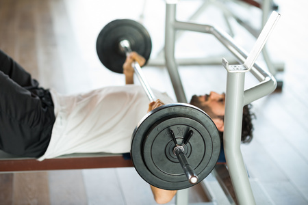 Bodybuilder lifting a weight on the flat bench