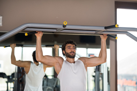 Man doing pull-ups in a gym