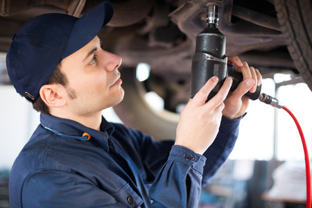 Mechanic repairing a lifted carの写真素材