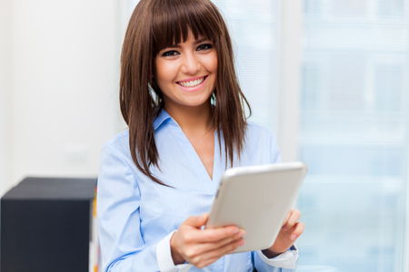 Cheerful businesswoman with a tablet in her officeの写真素材