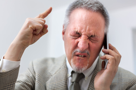 Portrait of an angry businessman yelling at phoneの写真素材