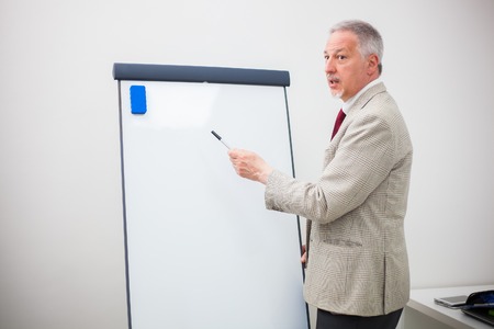 Businessman showing data on a whiteboard during a meeting