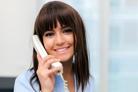 Young smiling businesswoman talking on the phoneの写真素材