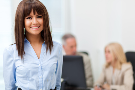 Portrait of a smiling young businesswoman in a bright officeの写真素材