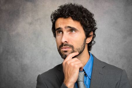 Pensive businessman against a grungy backgroundの写真素材