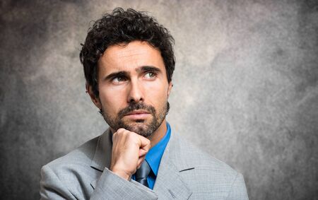Pensive businessman against a grungy backgroundの写真素材