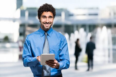 Portrait of a young business man holding his tabletの写真素材
