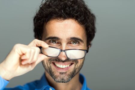 Portrait of a handsome man holding eyeglassesの写真素材