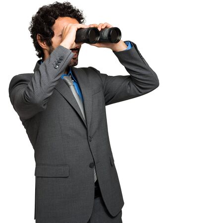 Businessman looking through binocularsの写真素材
