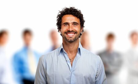 Portrait of a young smiling man in front of a group of peopleの写真素材