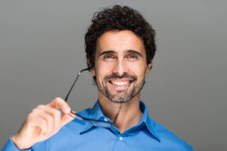 Portrait of a handsome man holding eyeglassesの写真素材