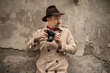 Spy or paparazzo photographer, man using camera in a city street