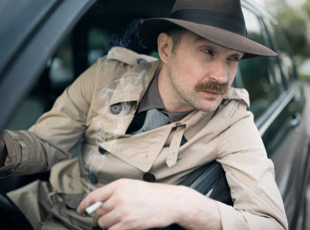 Detective waiting for someone in his carの写真素材