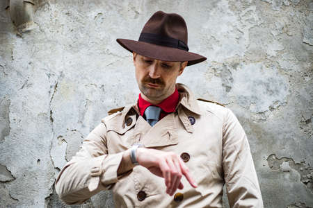 Investigator checking the time on his watch, waiting for the suspect to show upの写真素材