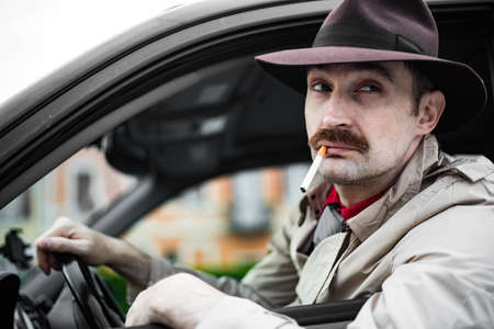 Detective smoking a cigarette in his car while stalkingの写真素材