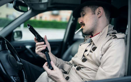 Man preparing his gun inside a carの写真素材