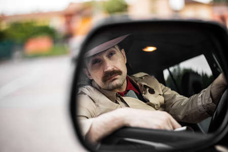 Detective smoking a cigarette in his car while stalkingの写真素材