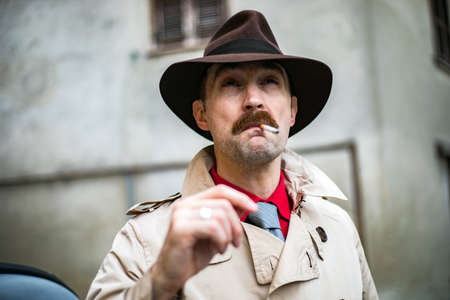 Vintage detective tuxedo at cigarette ina city slumの写真素材