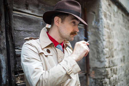 Vintage detective tuxedo at cigarette ina city slumの写真素材