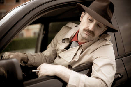 Detective smoking a cigarette in his car while stalkingの写真素材