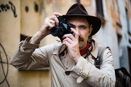 Detective taking pics in a sity slum with his vintage cameraの写真素材