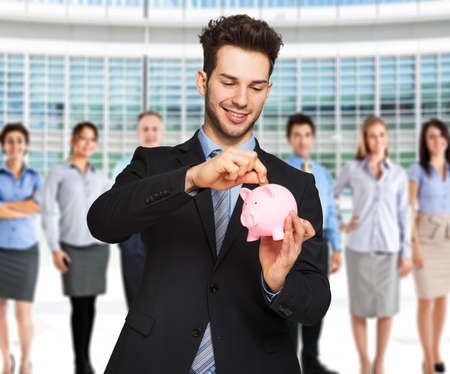 Man putting money in a piggy bankの写真素材