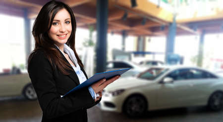 Saleswoman with folder and auto show backgroundの写真素材