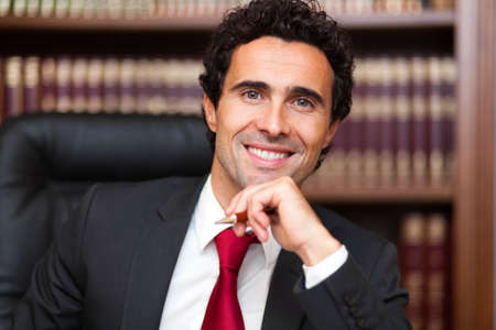 Portrait of an handsome smiling businessman in his officeの写真素材