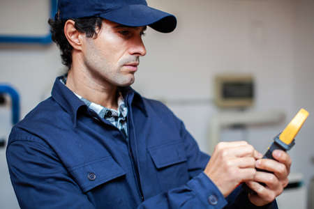 Electrician using a tester while working in a customer's houseの写真素材